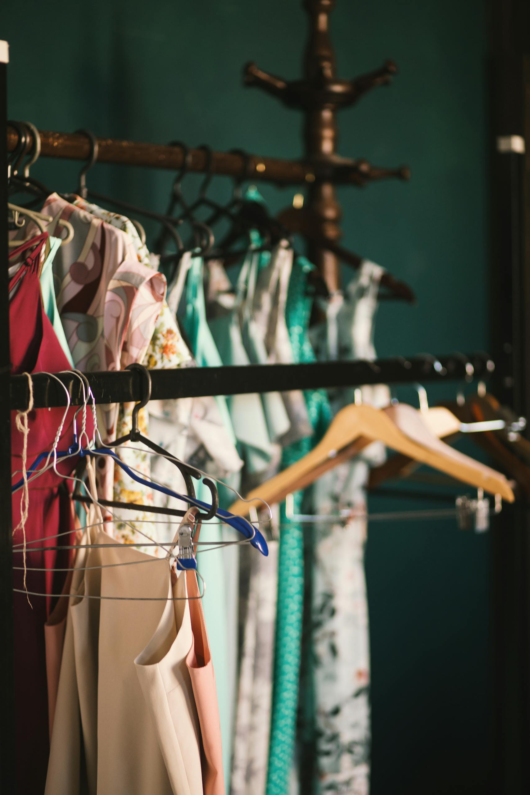 A collection of elegant dresses hanging on a clothes rack in a stylish wardrobe setup.